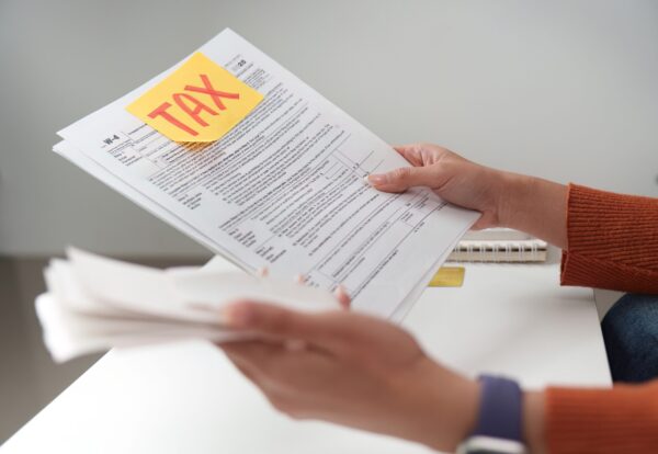 A person examines tax paperwork with a focus on accuracy and organization, preparing for tax submission.