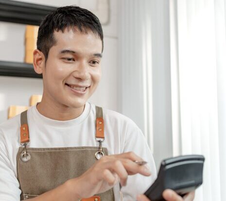Trabajador hispano de restaurante revisando sus propinas y su cheque antes de la temporada de impuestos.